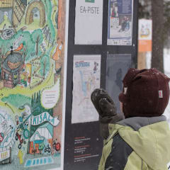 A boy is watching a information board.