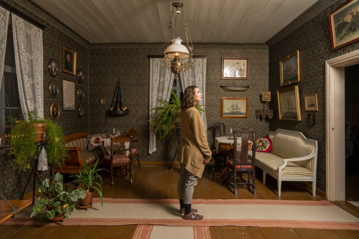 A person admiring the shipmaker's room in Sovelius House