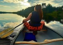 Woman paddling with a canoe in Lake Lentiira.