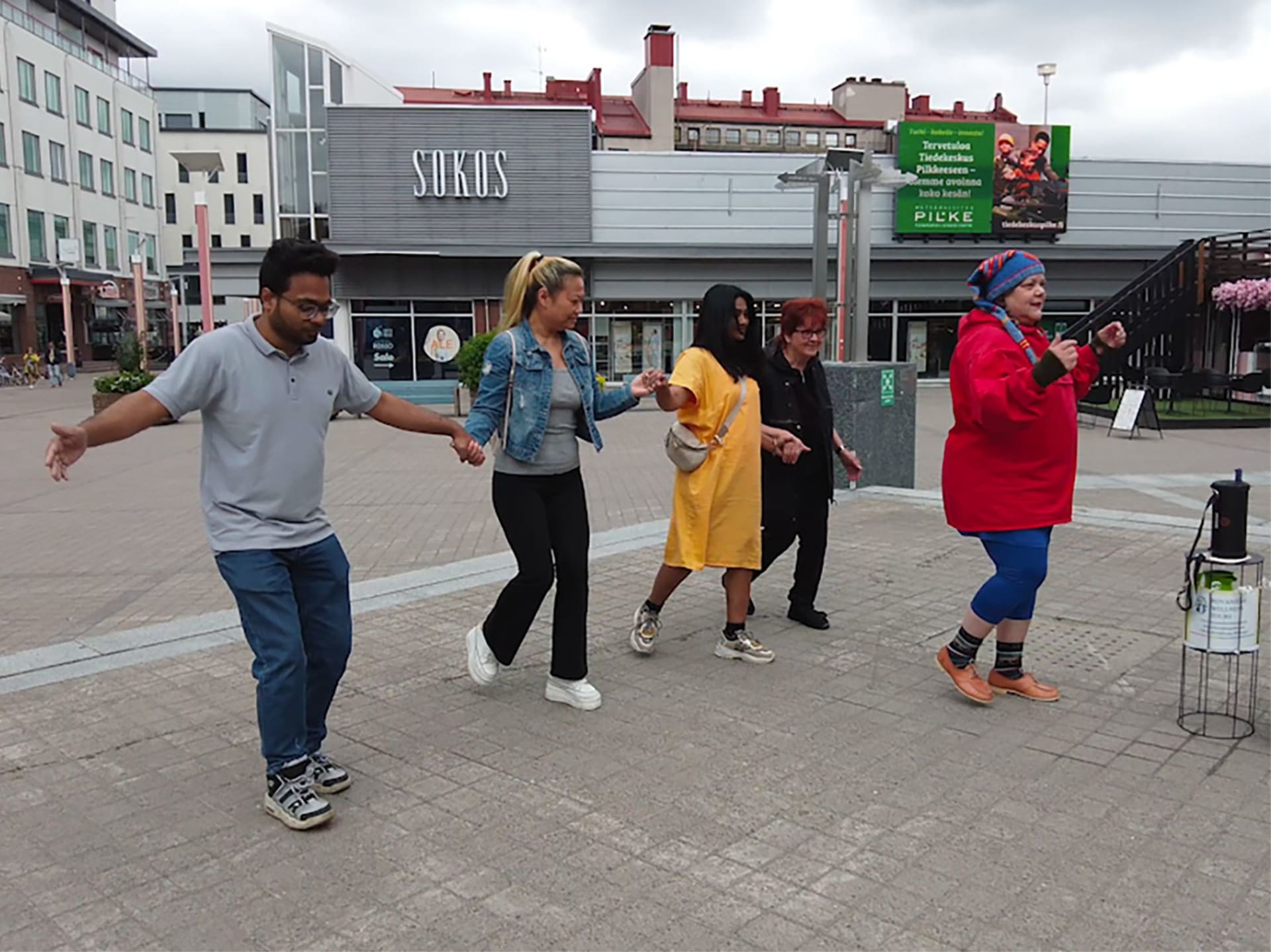 Man and three ladies dancing with Good Will Elf at the Lordi Square.
