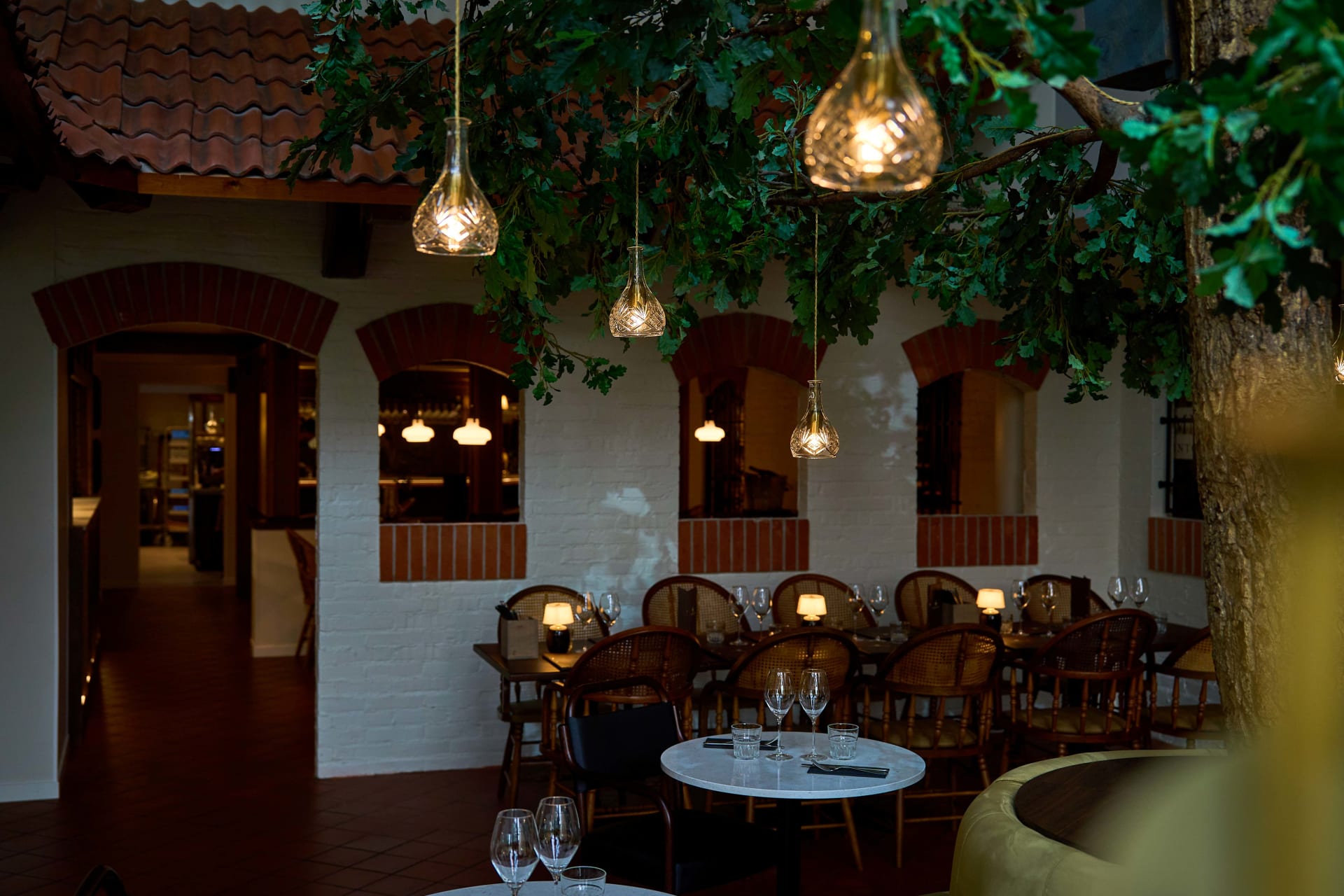 Hämyinen ravintolatila, jossa pöytiä ja tuoleja Hämyinen ravintolatila, jossa pöytiä ja tuoleja