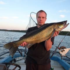 A man showing a really big fish on his hands, a pike