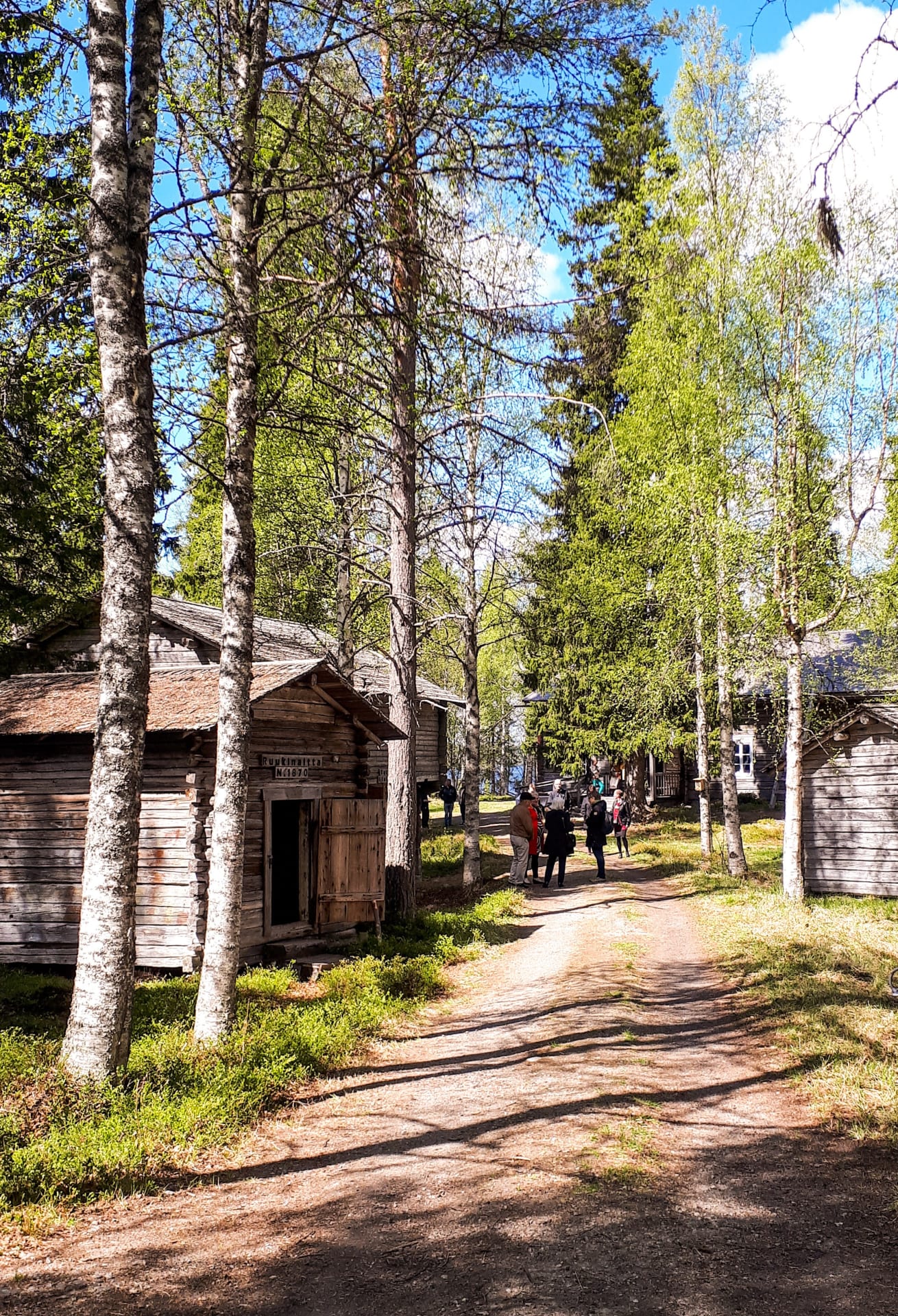 Suomussalmen kotiseutumuseon portilta johtaa leveä polku museon pihapiiriin.