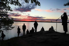 People on a lakeside by sunset