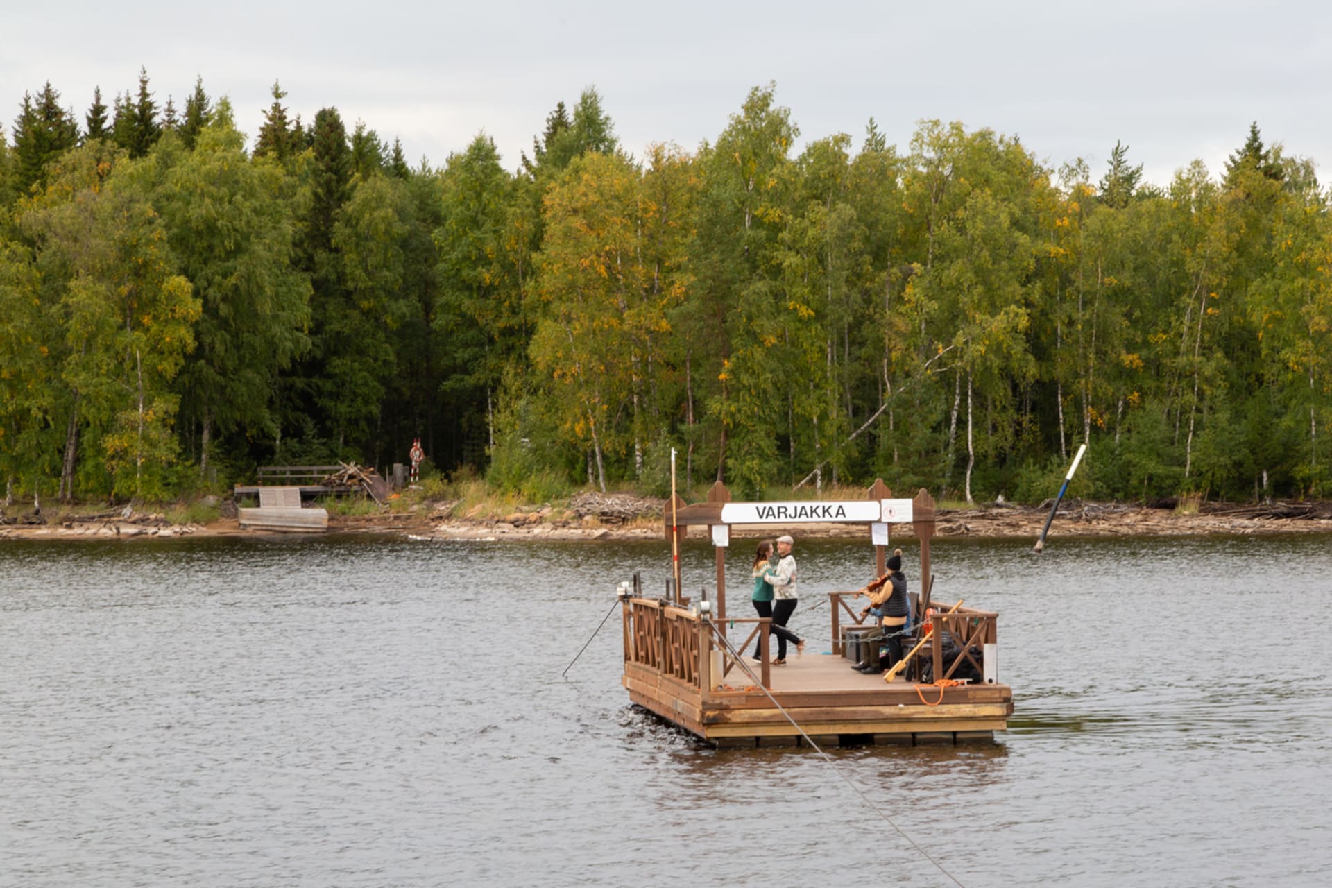 Visitors in a hand-winched block ferry going to Varjakka island.