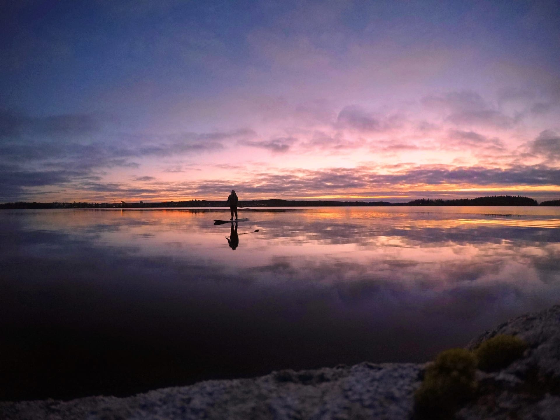One person is stand up paddling in colorful sunset scenery on lake Pyhäjärvi.