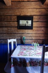 Pöytä hirsiseinäisessä huoneessa.