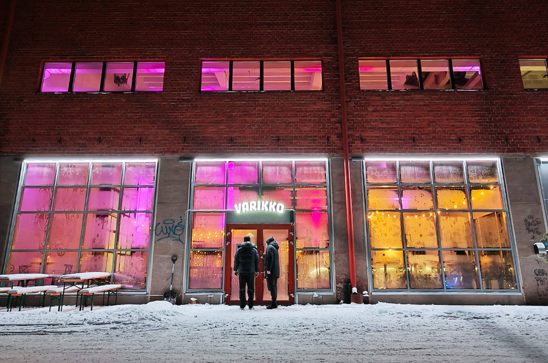 The historic Varikko brewery building glowing with purple lights during a Nordic evening