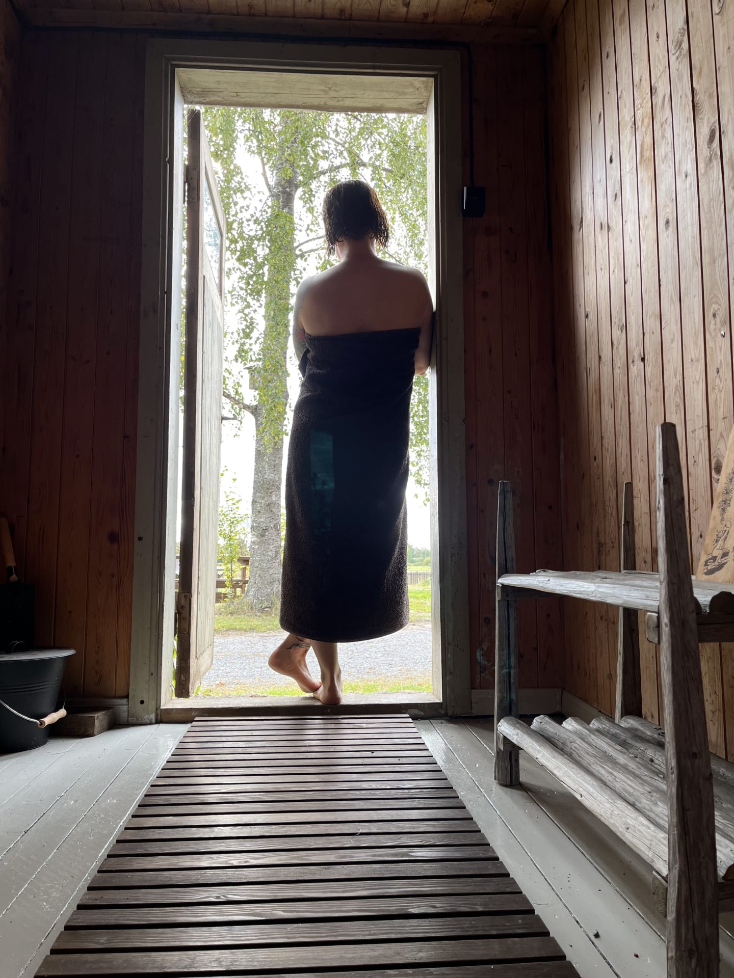 Nainen seisomassa saunan ovella