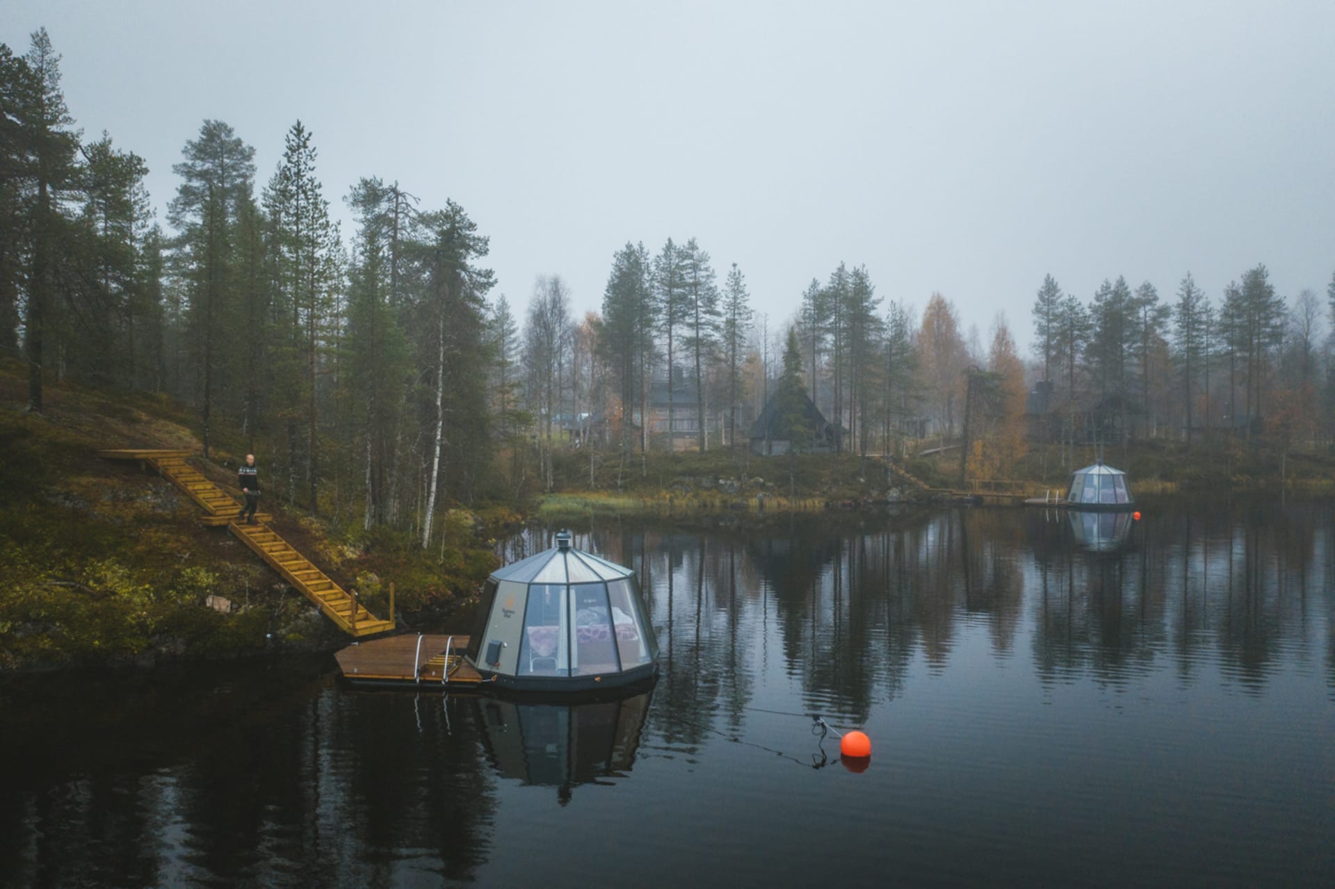 AuroraHut and main building at Isokenkäisten Klubi on a misty autumn day