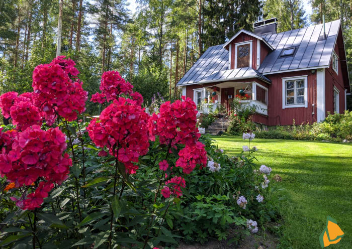 Red flowers and the red Old Cottage, which is over 100 years old