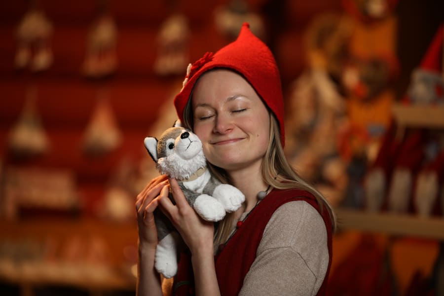 Annikki the elf hugging a husky cuddly toy.