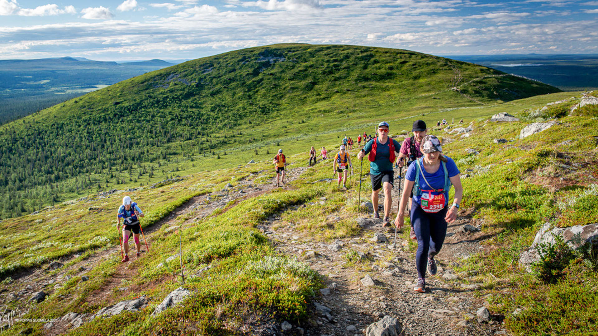 Trail runners hiking up on a fell on a sunny day