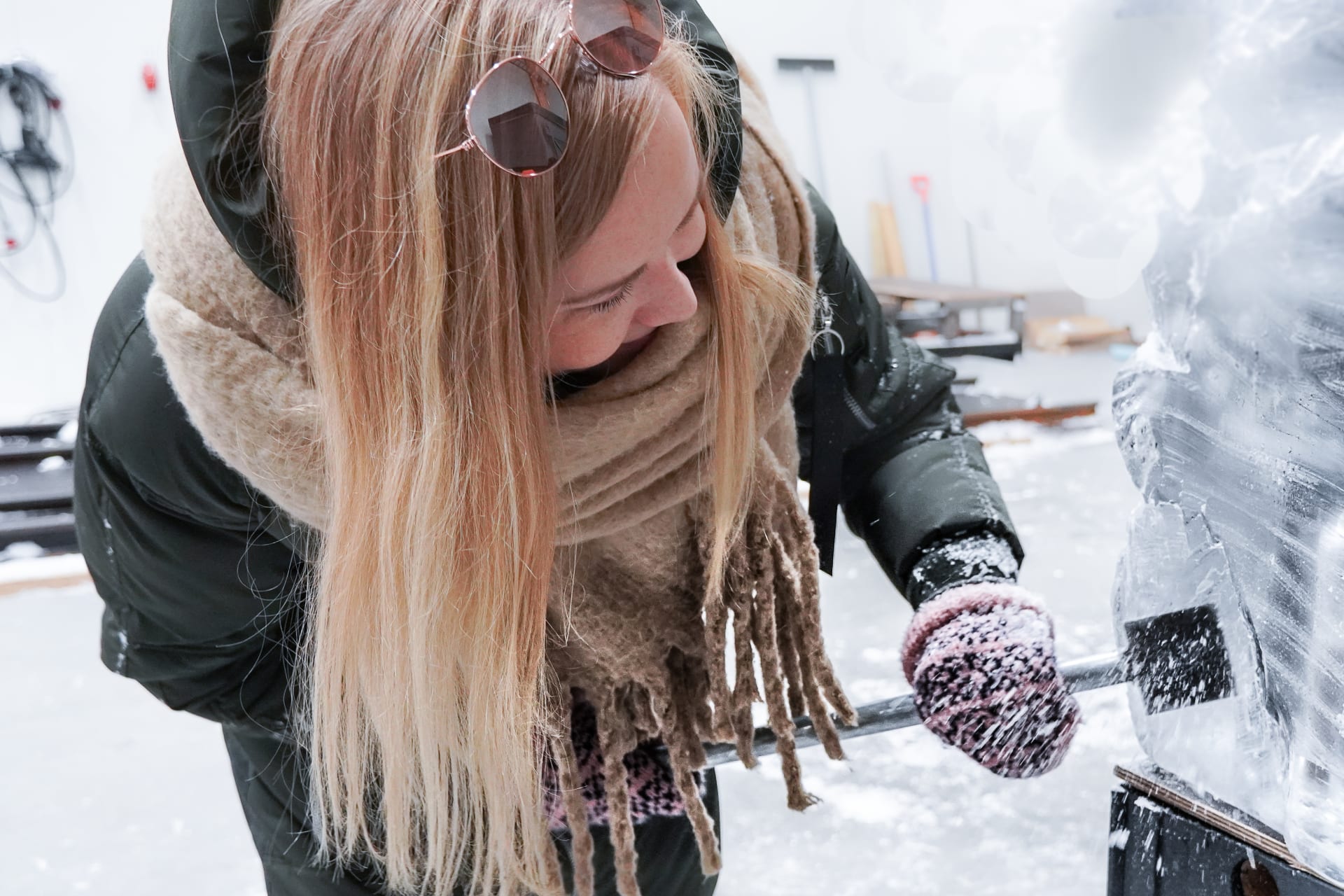Woman ice sculpting at ice sculpting workshop at Arctic SnowHotel in Rovaniemi, Lapland, Finland
