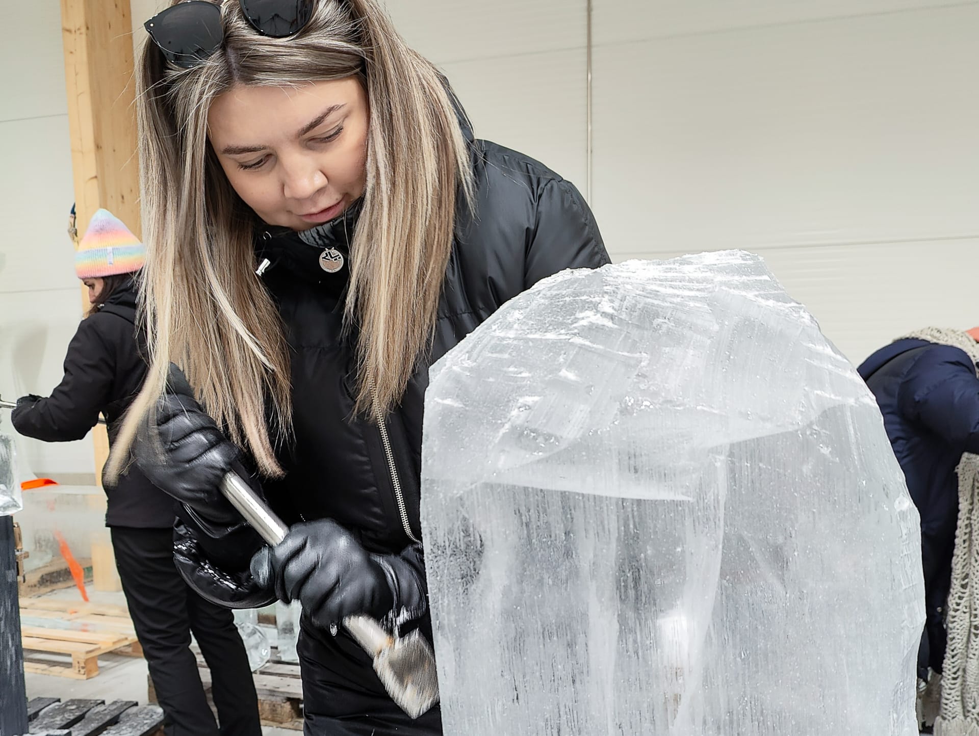 Woman ice sculpting at ice sculpting workshop at Arctic SnowHotel in Rovaniemi, Lapland, Finland