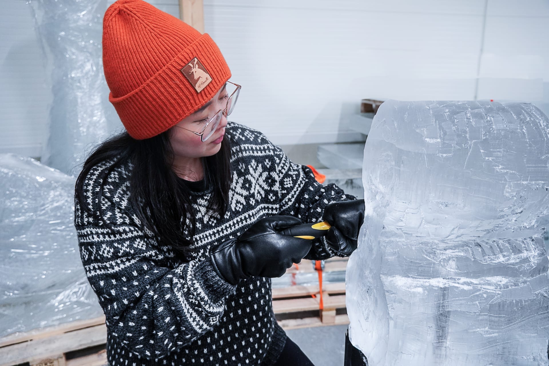 Woman ice sculpting at ice sculpting workshop at Arctic SnowHotel in Rovaniemi, Lapland, Finland