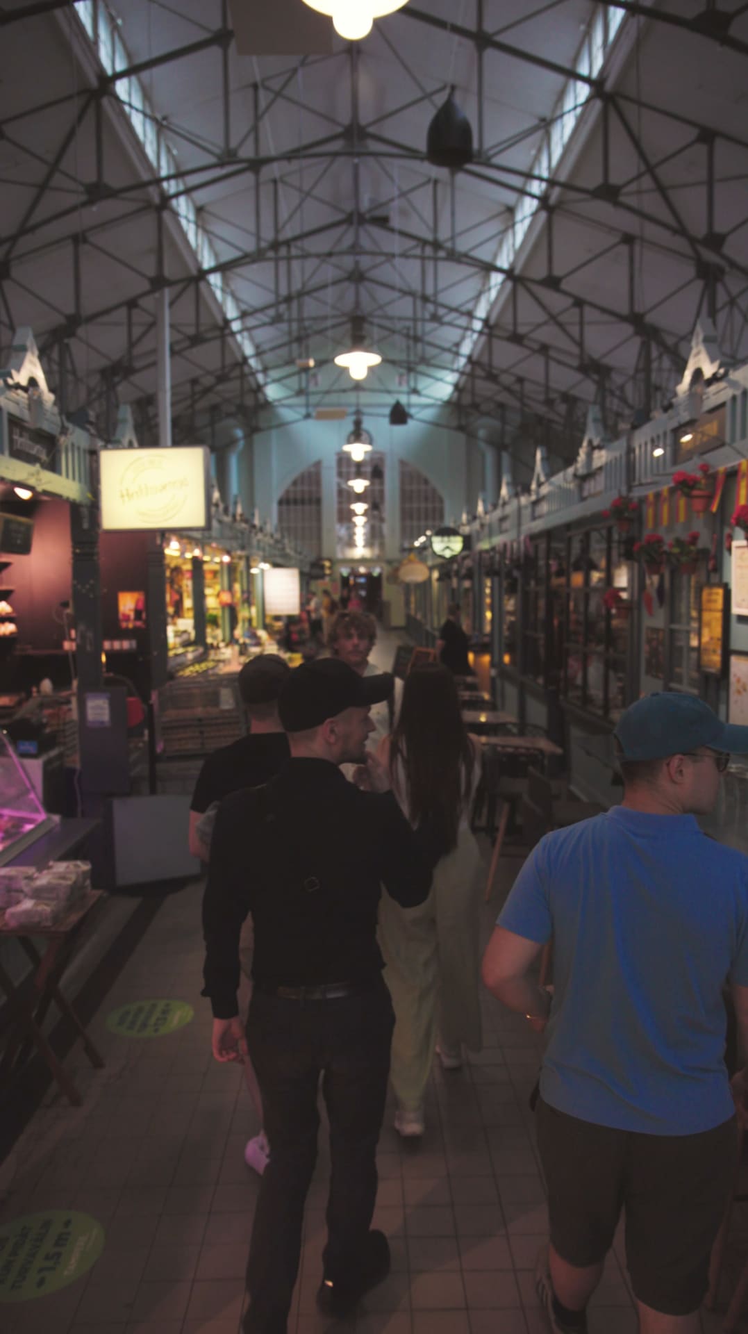 Kauppahallissa kävelevät ihmiset