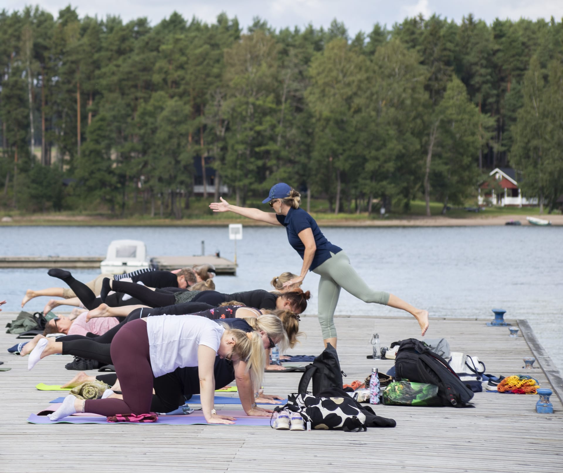 Yoga teacher giving instructions for yoga students on the pier.