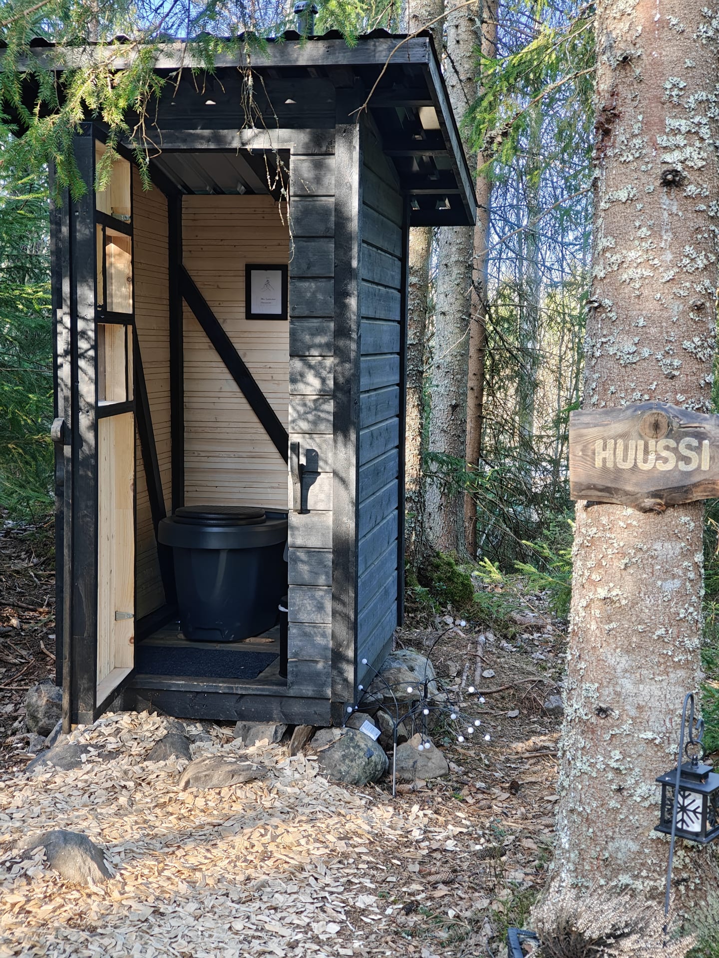 Metsässä on siisti ulkohuussi.