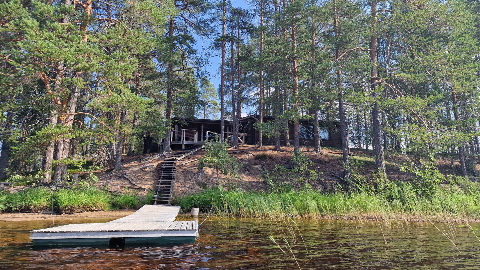 Erämökki omassa saaressa Hossanjärvellä laiturin ja rantamaiseman äärellä