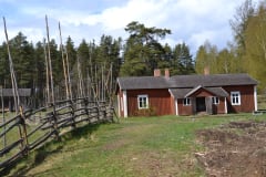 Talo, jonka edustalla on ruohokenttä ja vieressä riukuaita.Kuva: Outi Mäenpää.