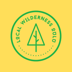 Local Wilderness Oulu logo. Green logo on yellow background. A circle that has a tree in it and the text Local Wilderness Oulu.