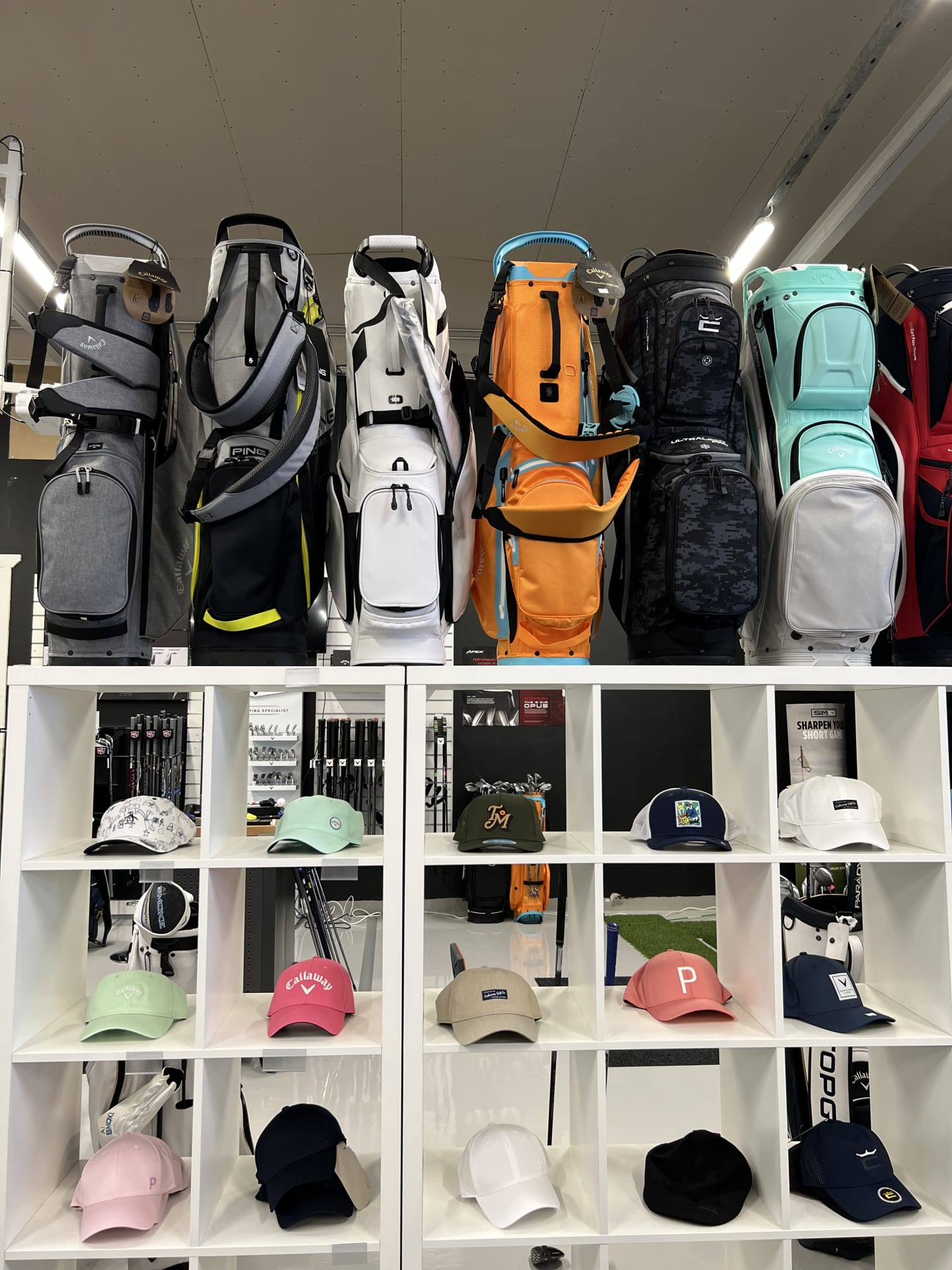 GOLFIN golfmyymälän golfbägejä ja lippalakkeja.