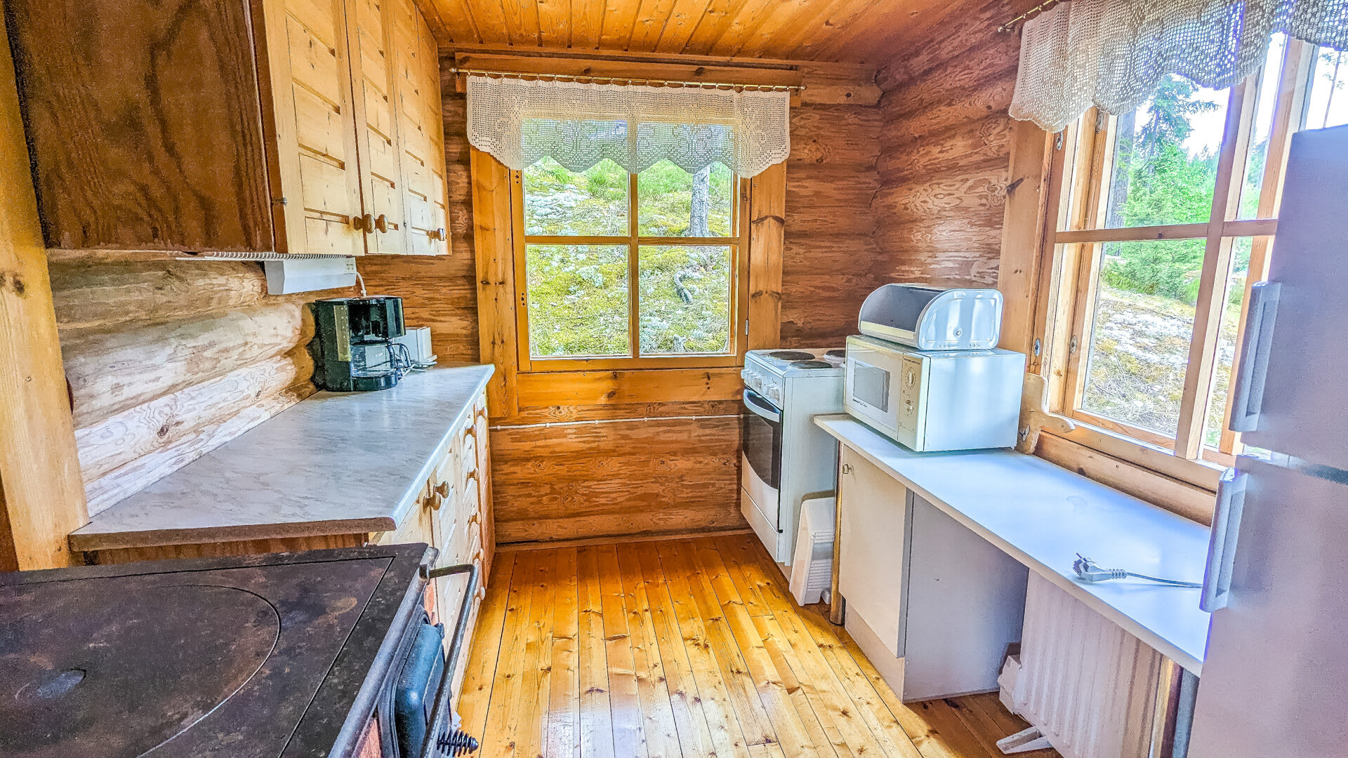 Well-equipped kitchen with stove, refrigerator, microwave, water cooker, coffee machine, cutlery
