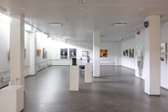 Galleria 2 yleiskuva. Seinillä värikkäitä maalauksia.