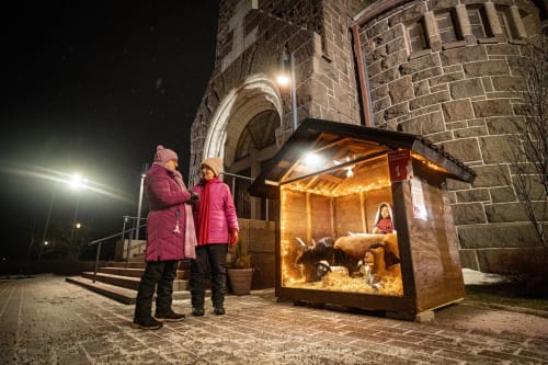 Kaksi henkilöä ihailemassa Wanhan Raahen joulukalenterin luukkua.