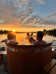 Miehet paljussa ilta-auringossa taustalla jokinäkymä