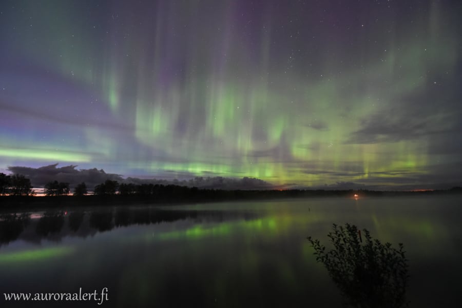 Auroras approaching over calm Lake 