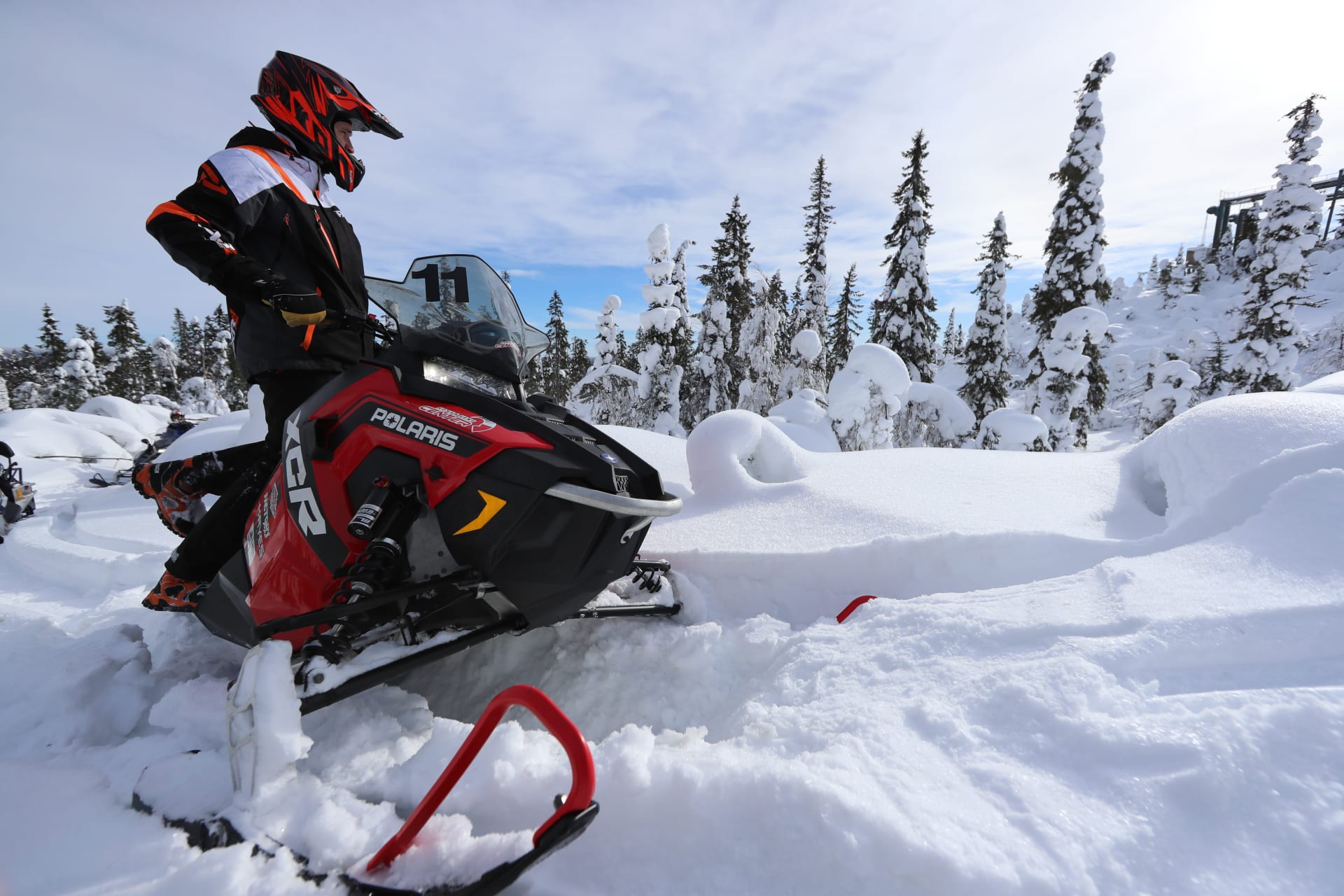 Snowmobile on snowy hill Moottorikelkka lumisella huipulla