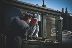 Two persons talking to each other in train windows