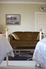 Sohva ja kaksi sänkyä vuokrahuoneessa