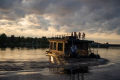 Saunalautta risteilemässä joella ilta-auringossa