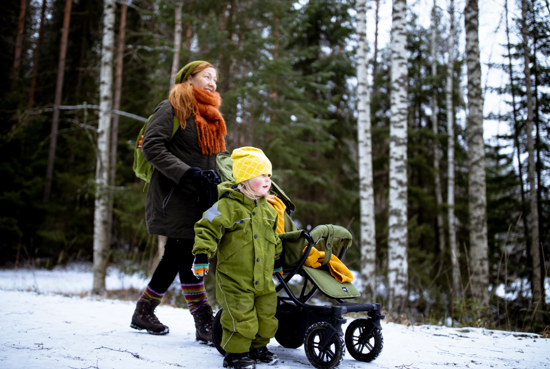 Äiti ja lapsi kävelevät talvisessa maisemassa rattaiden kanssa. kuva. Maarit Vaahteranoksa.