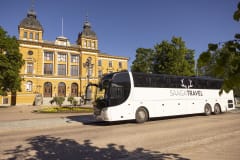 White bus in front of the Oulu city hall.