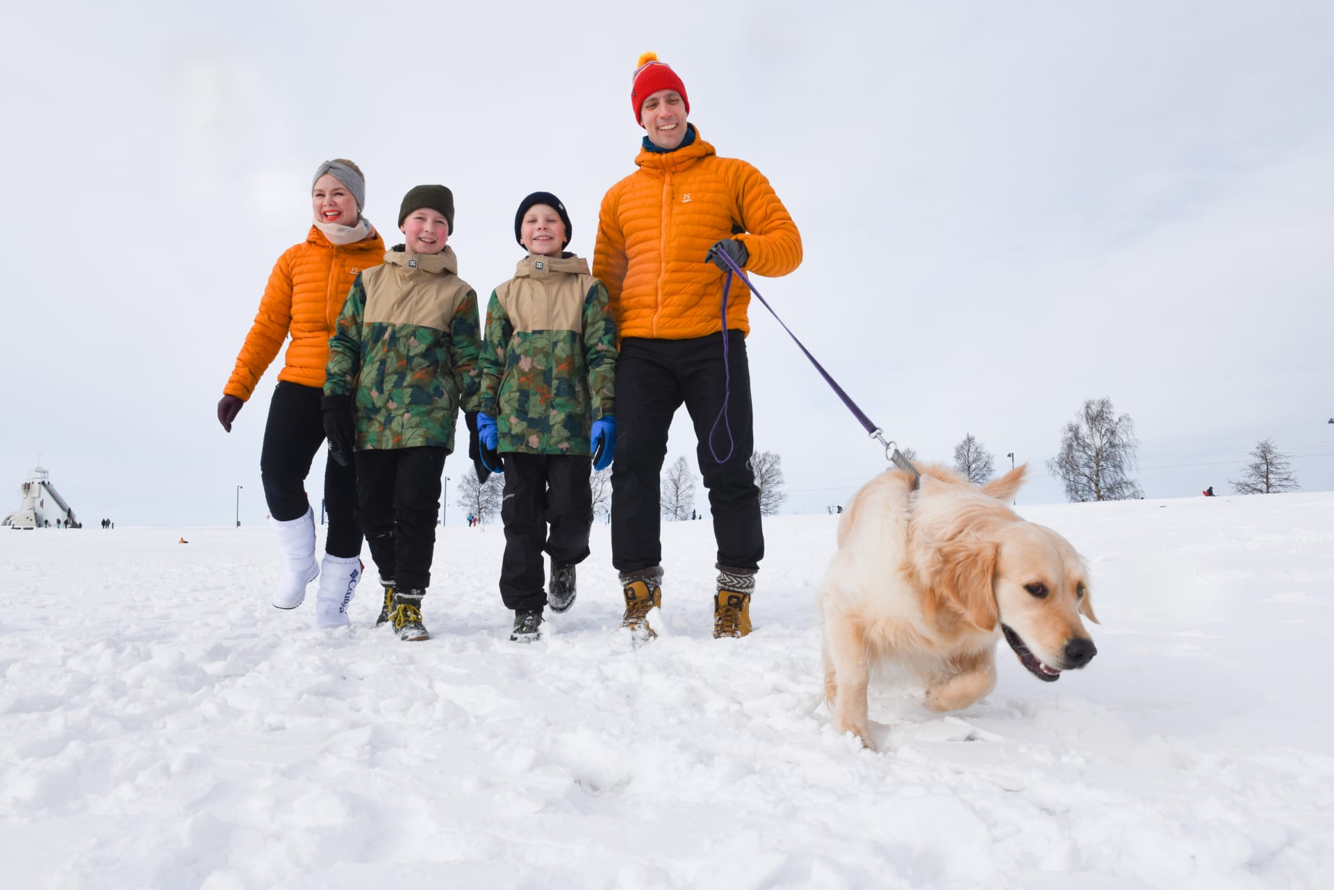 Family with a dog at the Nallikari beach in winter.