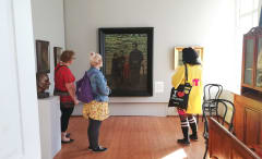 Three woman standing in front of Vilho Lampi art.