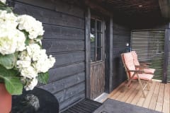 Riihisaunan terassilla on puutarhakalusteita.