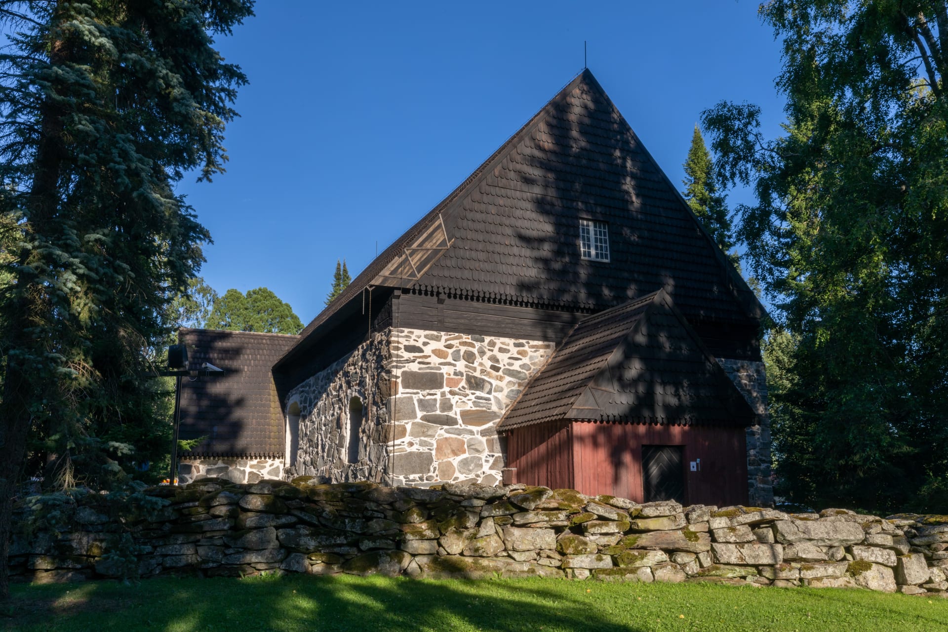 The medieval church is surrounded by a stone wall.