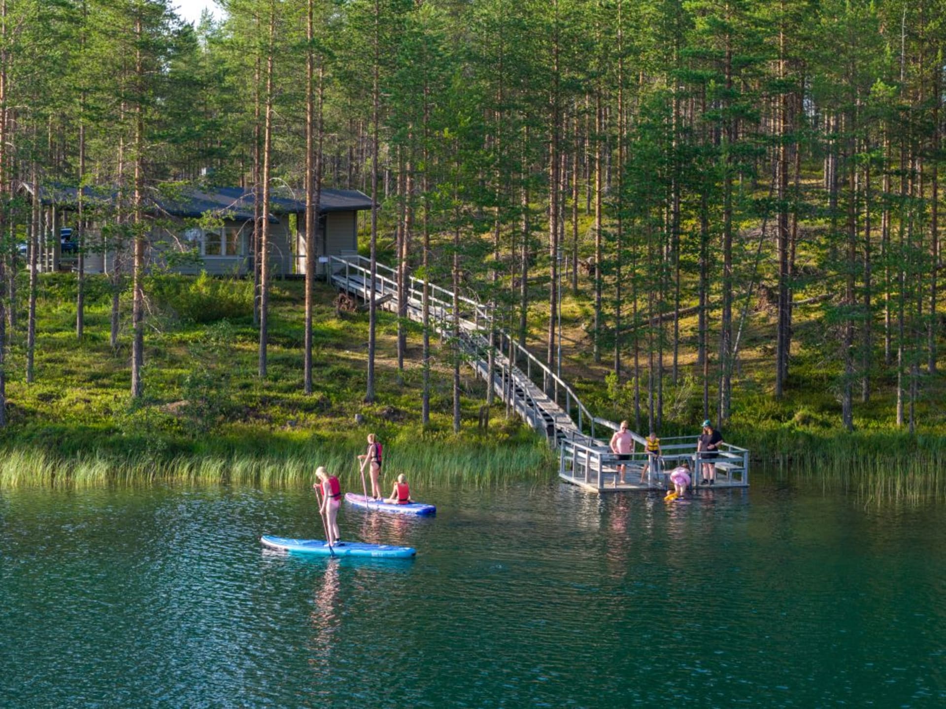 Uimareita ja Sup-lautailijoita Hossassa Öllörijärvellä
