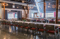 Juhla-aukiolla pitkiä pöytiä ja katossa koristevalot