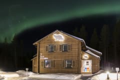 Holiday Villa under night sky full of Aurora Borealis