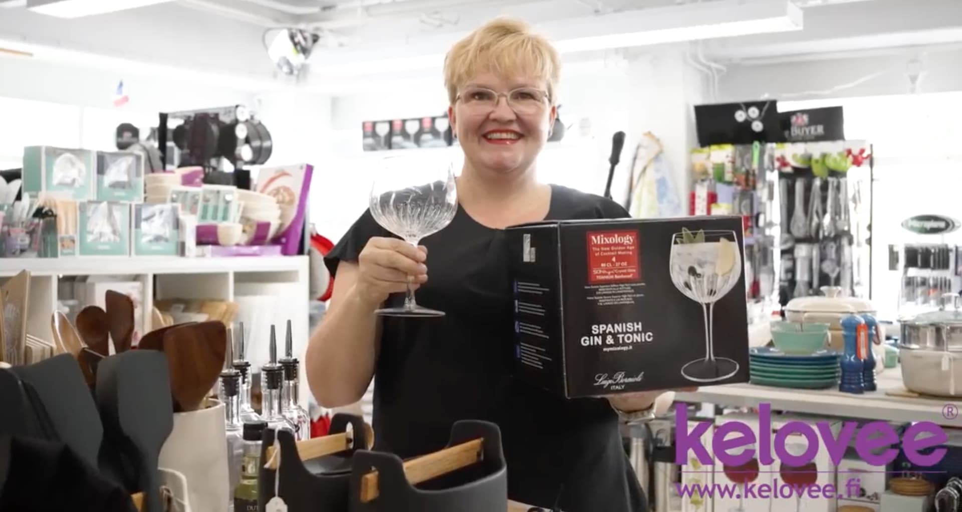 Woman presenting a gin and tonic glass. Nainen esittelee gin & tonic -lasia.