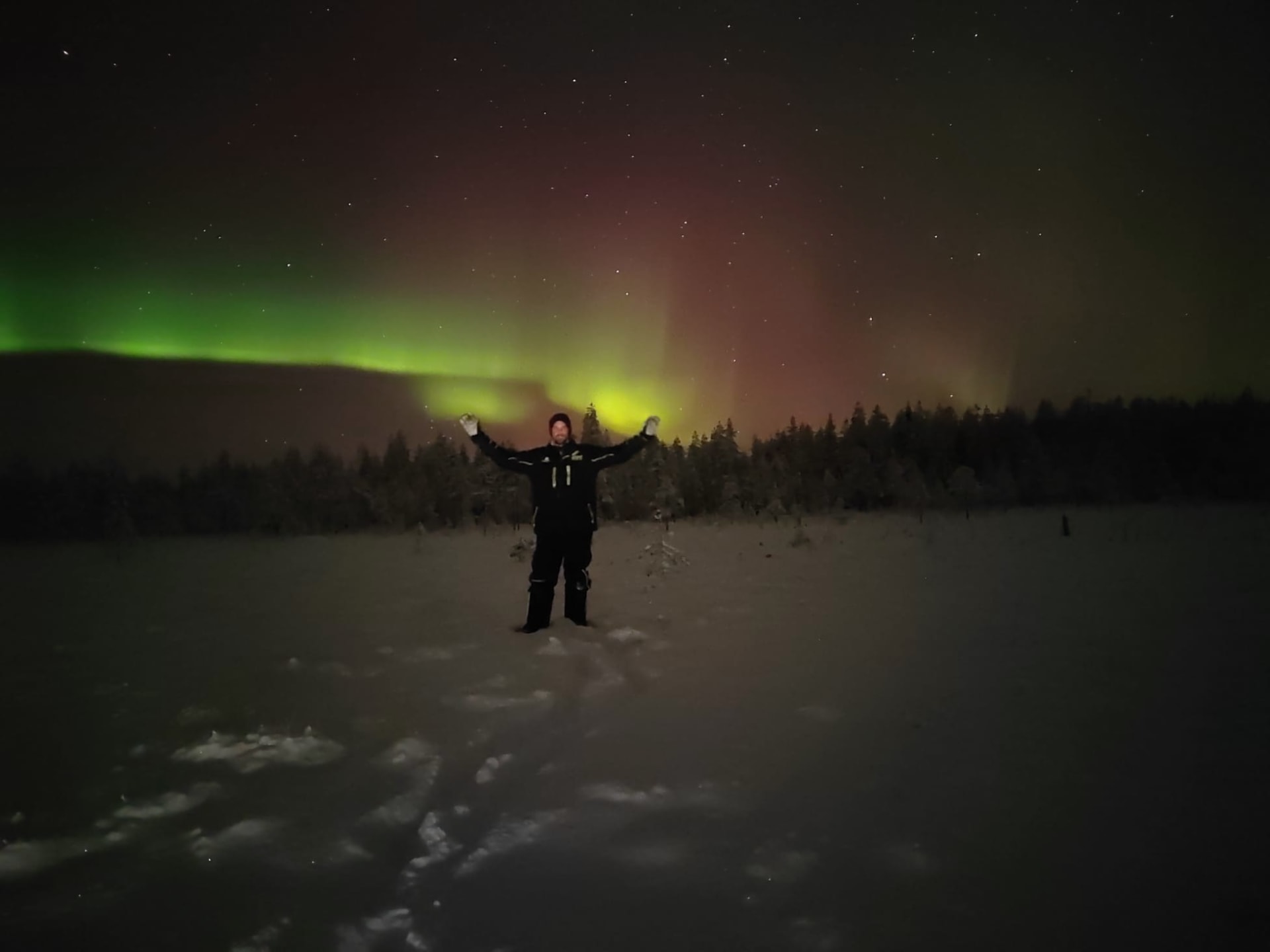 A guest posing in front of Aurora Borealis