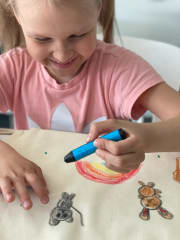 Lapsi piirtämässä narureppuun eläimiä ja sateenkaaren.