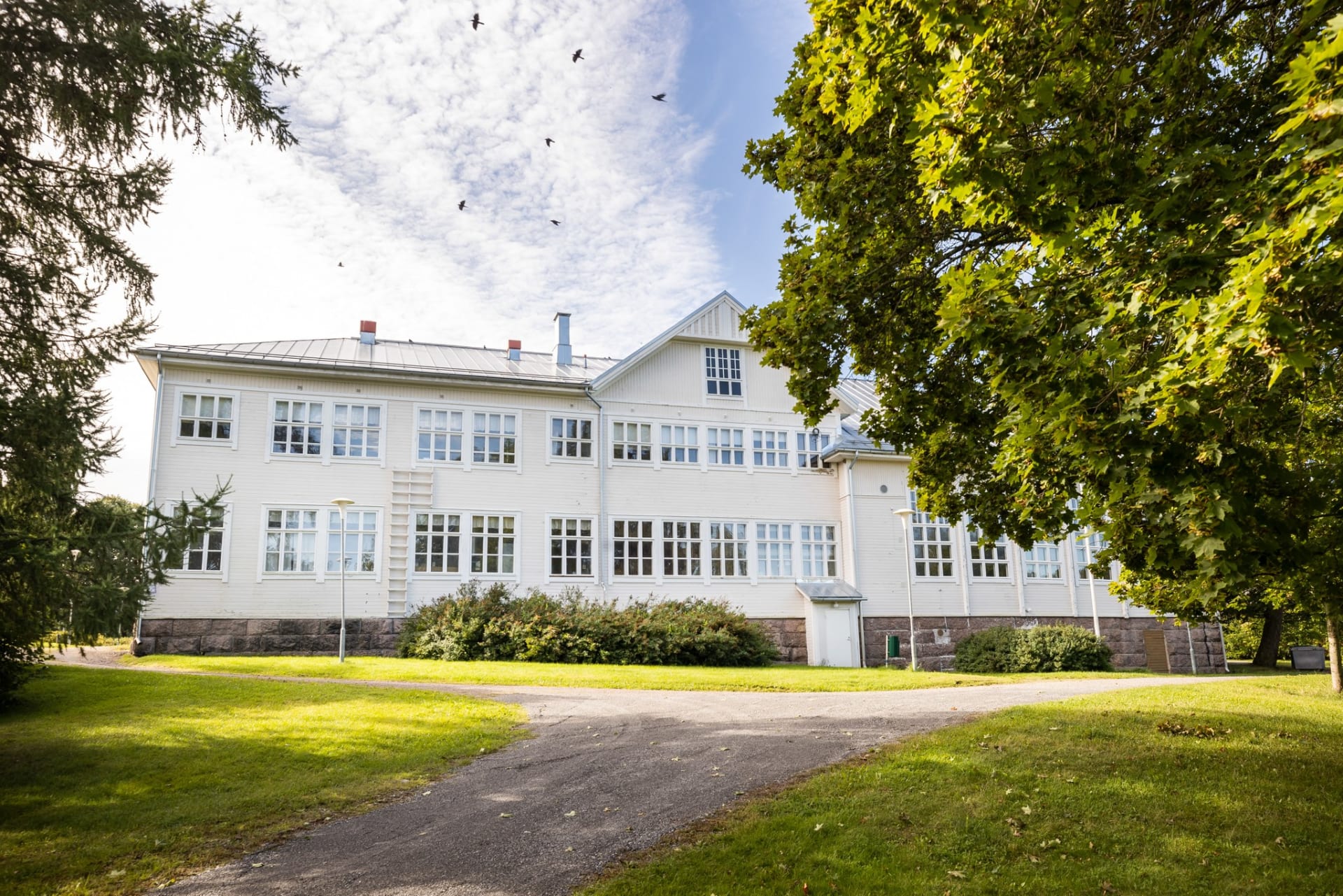 Valkoinen iso kartanomainen rakennus.