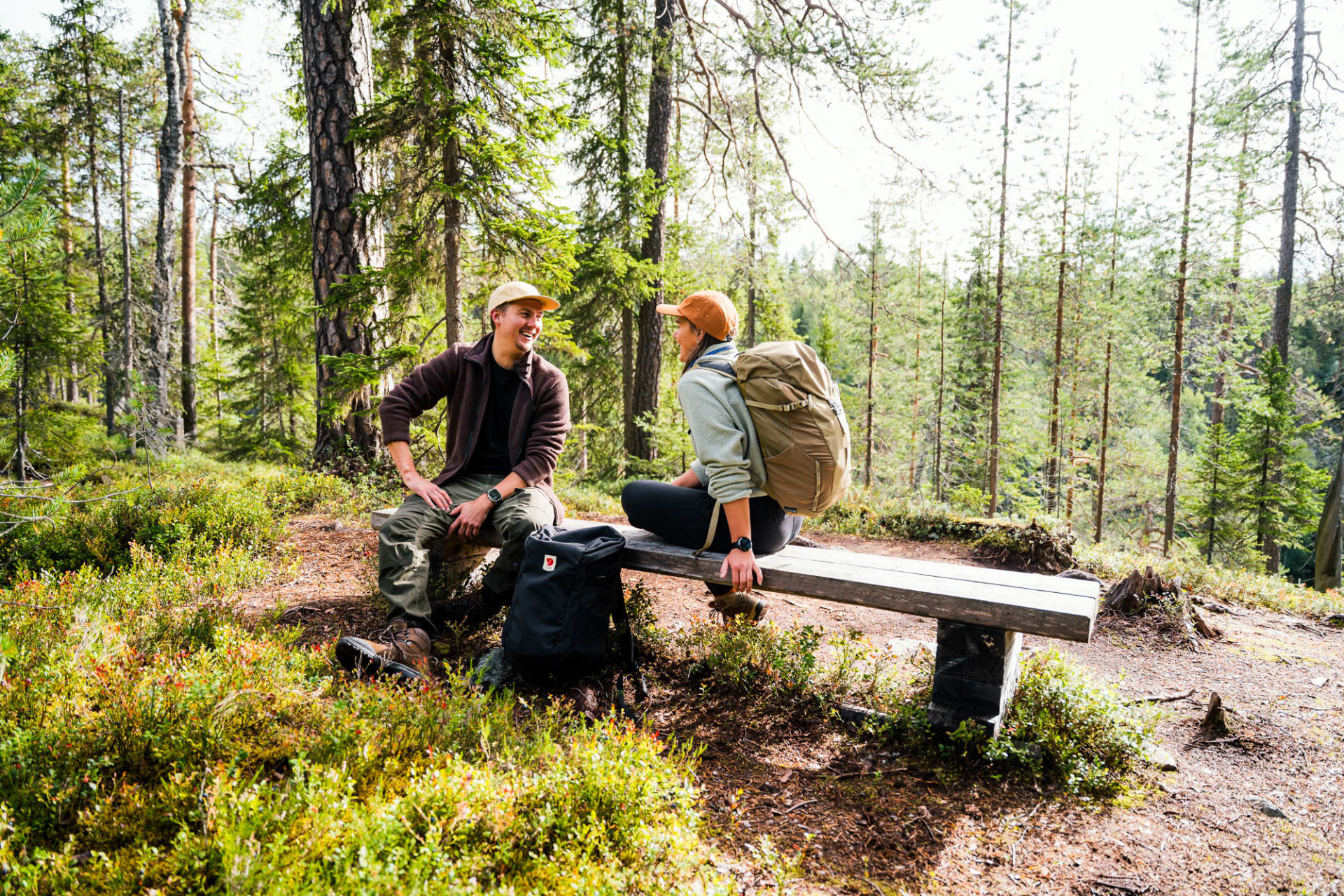 Retkeilijät istumassa keskellä kuusimetsää Hossan kansallispuistossa